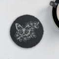 Round slate coaster laser engraved with a butterfly among cherry blossoms (product mockup)