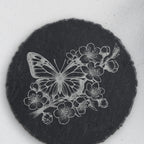 Close-up of the butterfly and blossom engraving on round slate (product mockup)