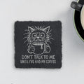 Square slate coaster engraved with a frazzled cat holding a mug and the words Don't Talk To Me Until I've Had My Coffee (product mockup)