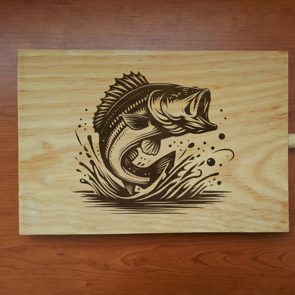 Light wood cutting board laser engraved with a largemouth bass leaping from a splash (product mockup)