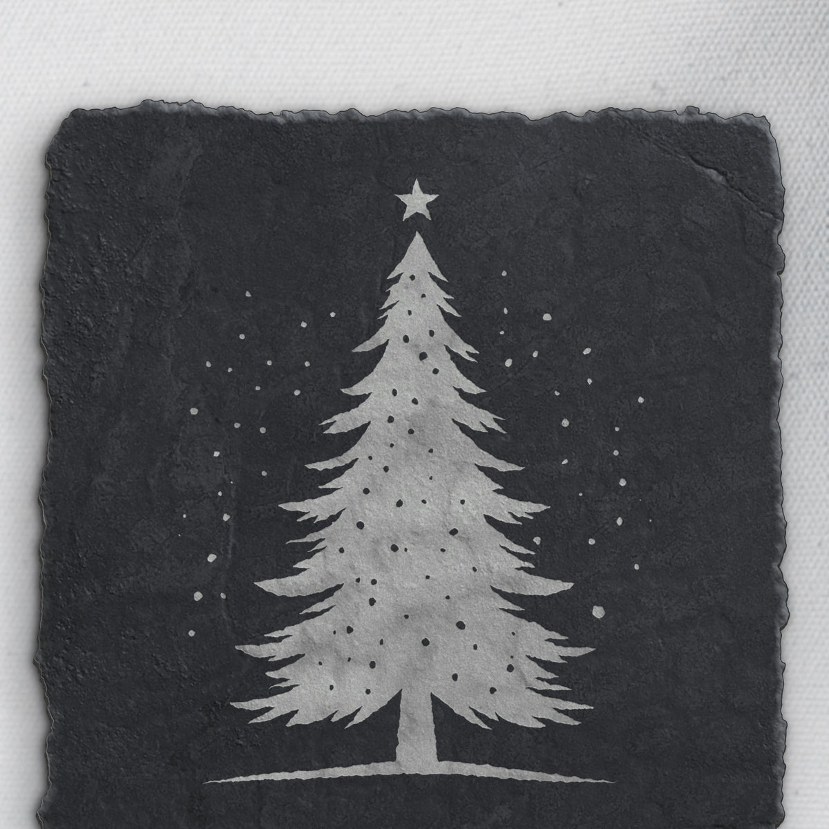 Snowy Christmas tree design on square slate, one of the four coasters in the mixed set (product mockup)