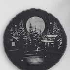Close-up of the winter cabin engraving on round slate (product mockup)