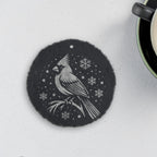 Round slate coaster engraved with a cardinal on a branch among snowflakes (product mockup)