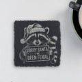 Square slate coaster engraved with a raccoon in a Santa hat holding a sign that says Sorry Santa I've Been Feral (product mockup)
