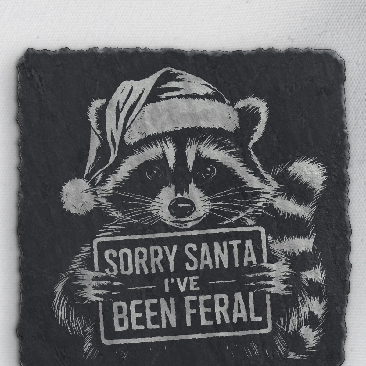 Close-up of the Santa-hat raccoon engraving on square slate (product mockup)