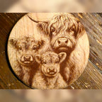Highland cow family, a mama and two calves, engraved on the designer's round wood sample (artwork preview)