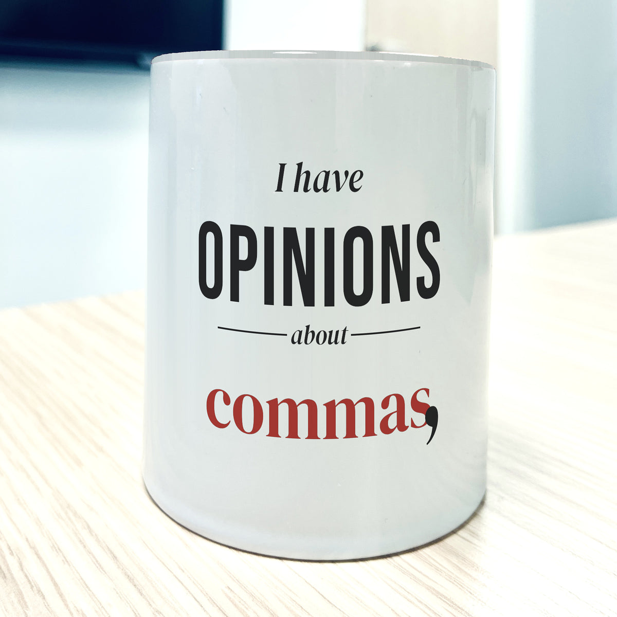 White 11oz mug, front view, printed "I have OPINIONS about commas," with "commas" in brick red and a large black comma.