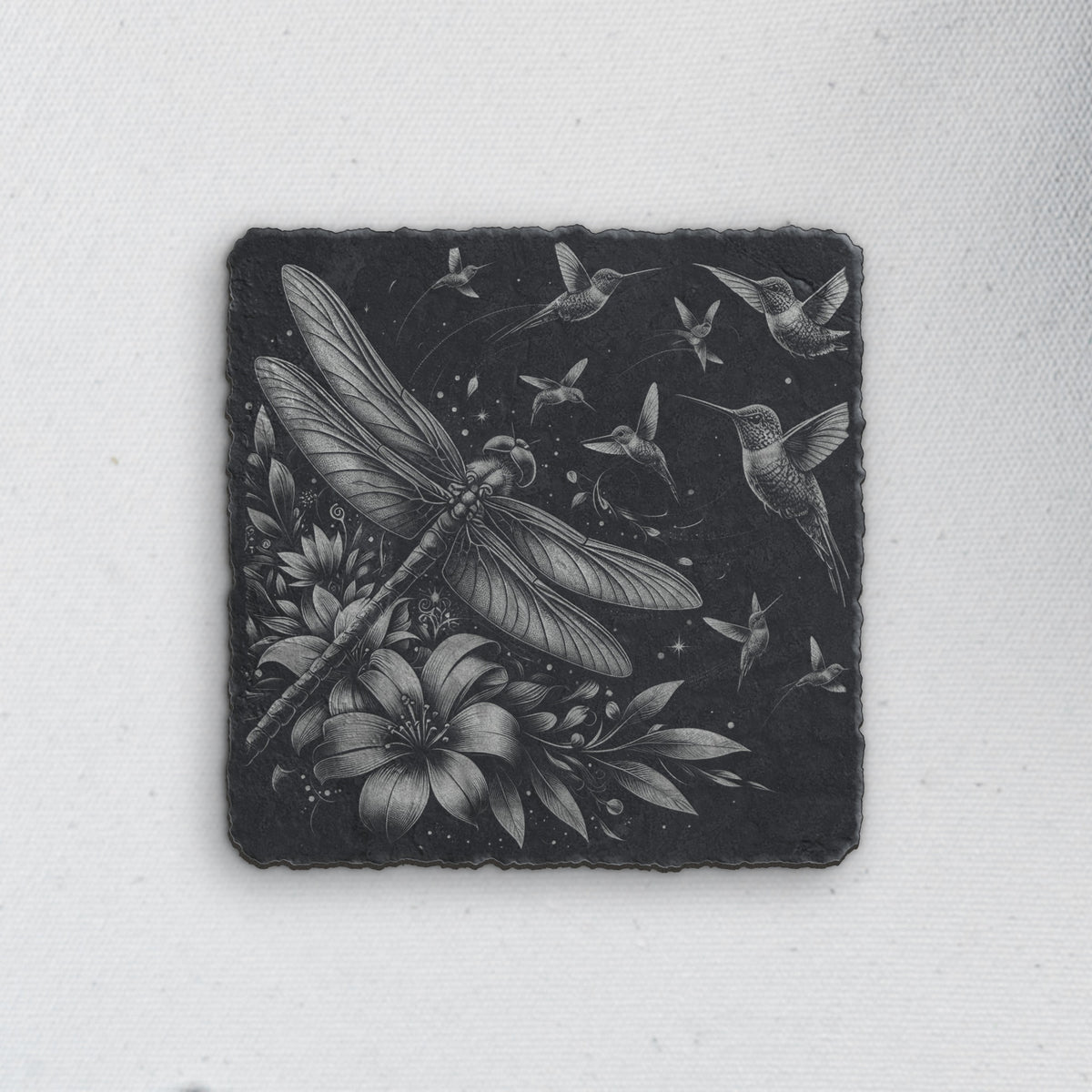 Square slate coaster engraved with a dragonfly, hummingbirds and flowers (product mockup)