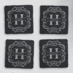Four square slate coasters engraved with a split-letter H monogram and the sample name Harper (product mockup)