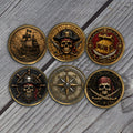 Six gold-tone pirate coins UV printed with a ship, skulls, a treasure chest and a compass rose on weathered wood (product mockup)