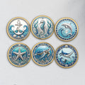 Six gold-tone ocean coins UV printed with an anchor, dolphin, sea turtle, starfish, seahorse and manta ray (product mockup)