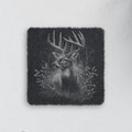 Square slate coaster engraved with a whitetail buck among forest trees and grasses (product mockup)