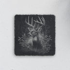 Square slate coaster engraved with a whitetail buck among forest trees and grasses (product mockup)